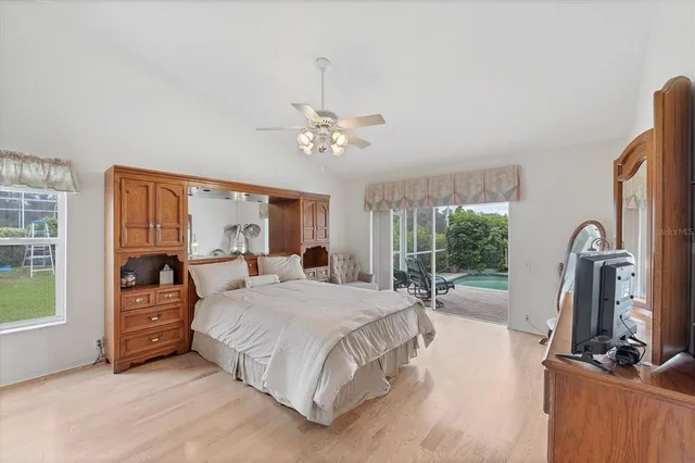 a spacious bedroom with a bed a chandelier and a large window with outer view
