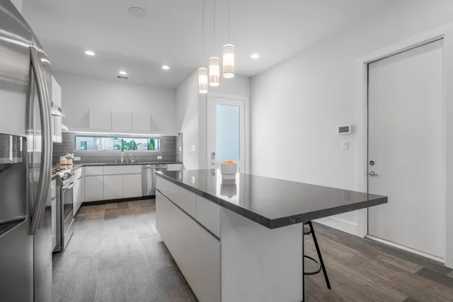 a kitchen with stainless steel appliances a sink a counter top space cabinets and wooden floor