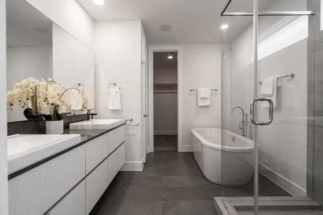 a bathroom with a double vanity sink a toilet and a shower