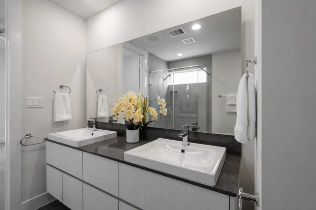 a bathroom with a sink double vanity granite and a mirror
