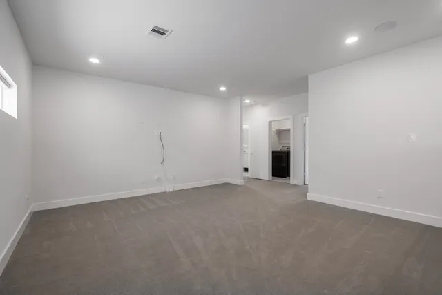 an empty room with an entryway and chandelier