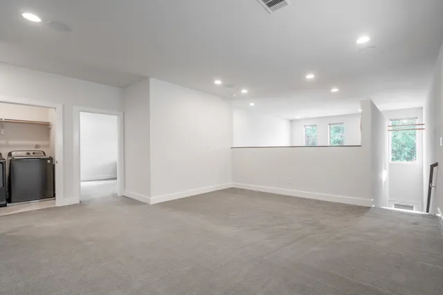 an empty room with windows and entrance to other room