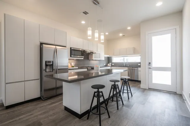 a kitchen with kitchen island white cabinets and stainless steel appliances