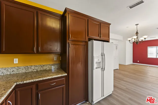 a kitchen with stainless steel appliances granite countertop a refrigerator and a stove
