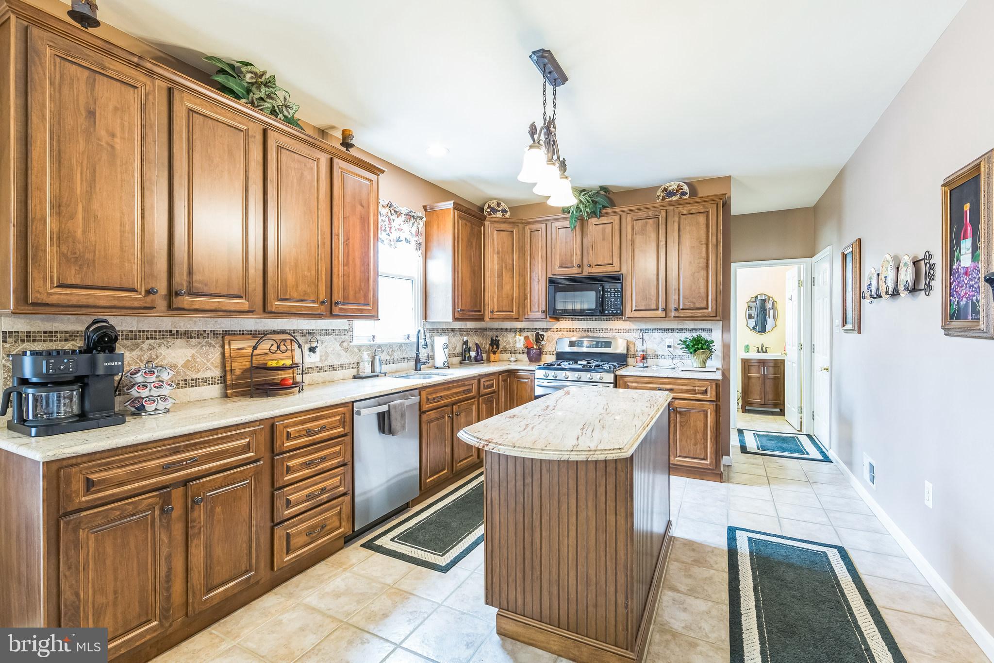 2902 Rosa Lane Norristown, PA 19403 - Photo 20 of 38 a kitchen with stainless steel appliances kitchen island granite countertop a refrigerator a sink dishwasher and white cabinets next to a window