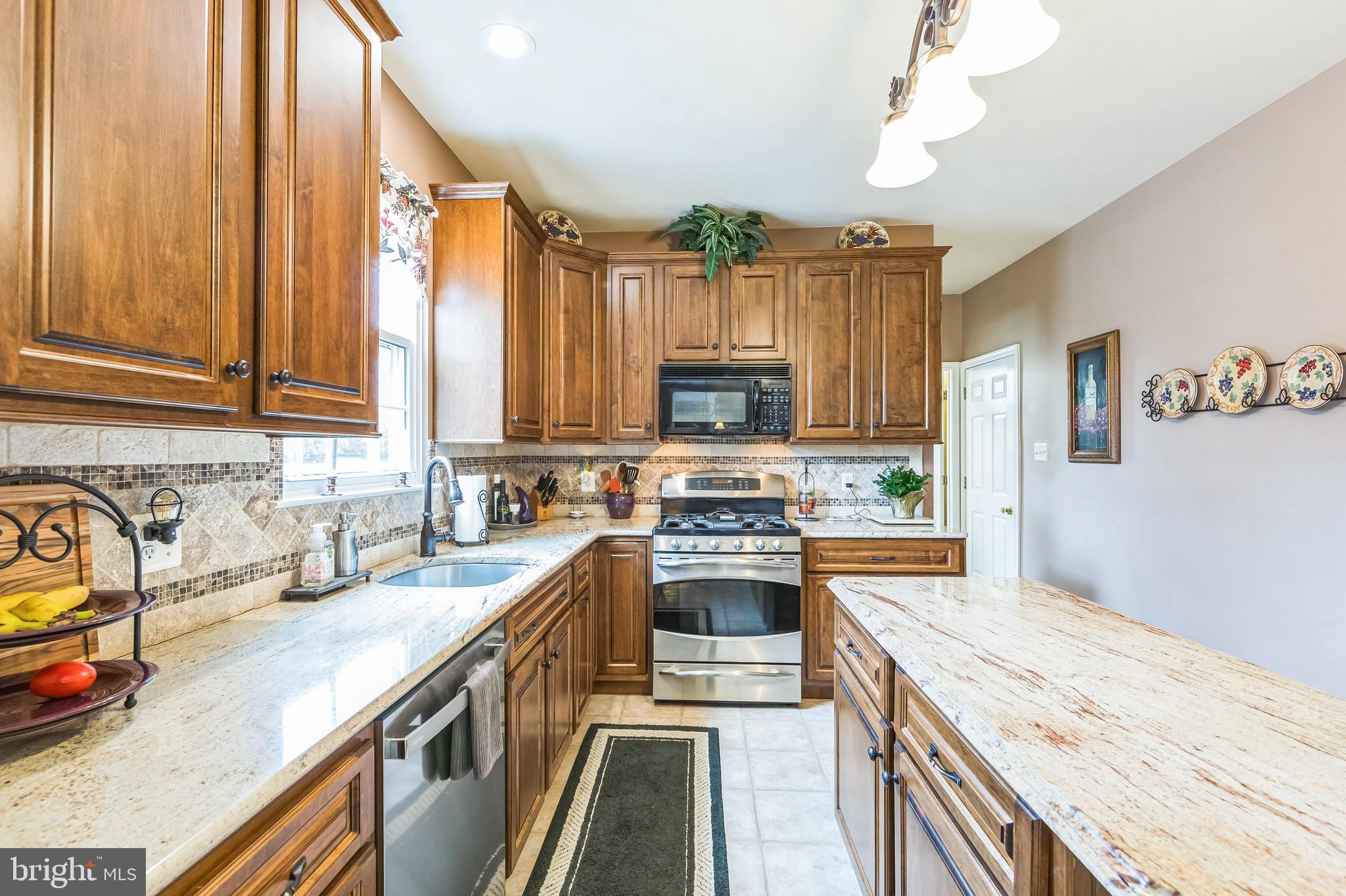 2902 Rosa Lane Norristown, PA 19403 - Photo 21 of 38 a kitchen with stainless steel appliances granite countertop a sink stove and refrigerator