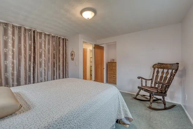 a bedroom with a chair and a dresser