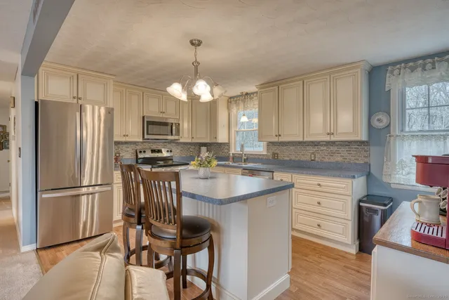 a kitchen with kitchen island granite countertop stainless steel appliances a stove refrigerator and microwave