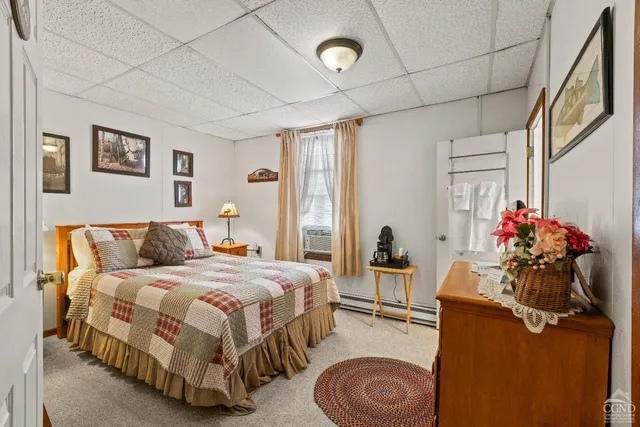 a bedroom with a bed and painting on the wall