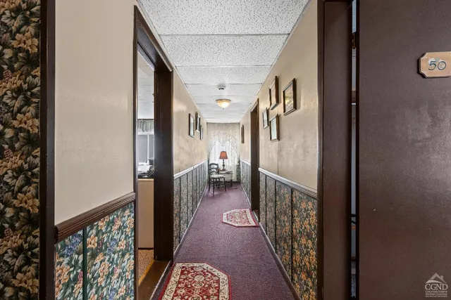 a front view of a building with lot of cars and trees