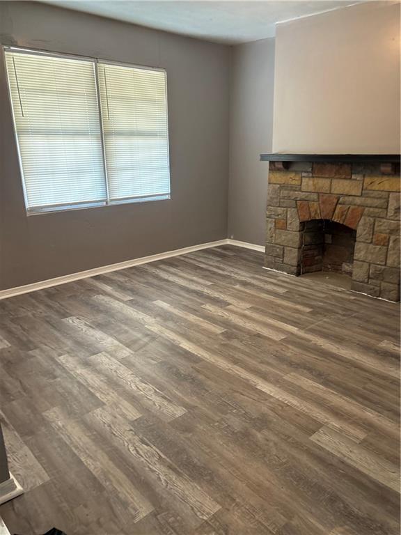 335 Cedarhurst Street Pittsburgh, PA 15210 - Photo 4 of 28 an empty room with wooden floor a fireplace and windows