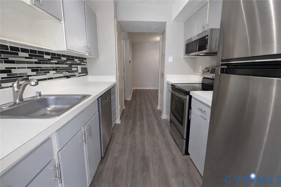 1501 Bronwyn Road, Unit 202 Henrico, VA 23238 - Photo 14 of 22 a kitchen with stainless steel appliances granite countertop a refrigerator a stove and a sink with wooden floor
