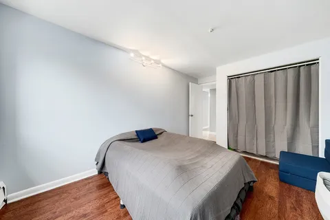a bedroom with a bed and wooden floor