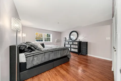 a living room with furniture a bed and wooden floor