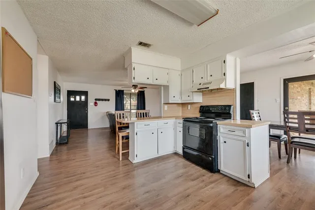 a kitchen with granite countertop white cabinets and stainless steel appliances
