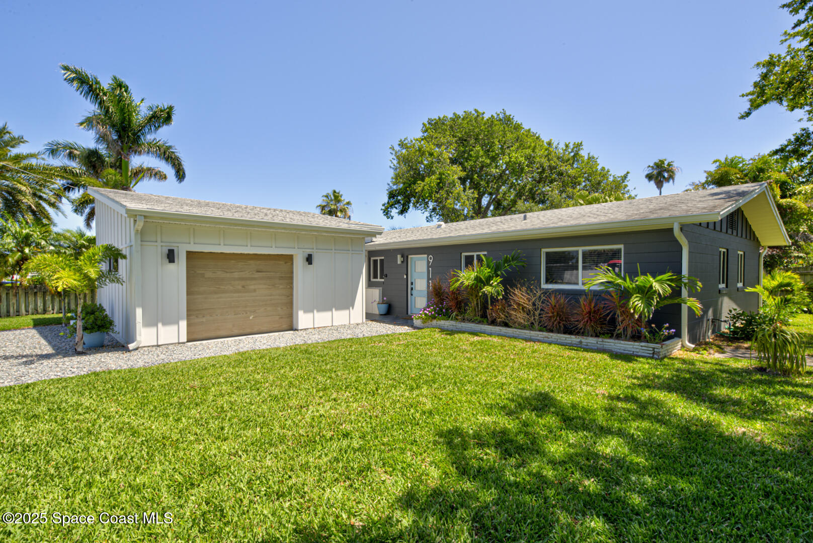 911 Bali Road Cocoa Beach, FL 32931 - Photo 30 of 66 a front view of house with a garden and patio
