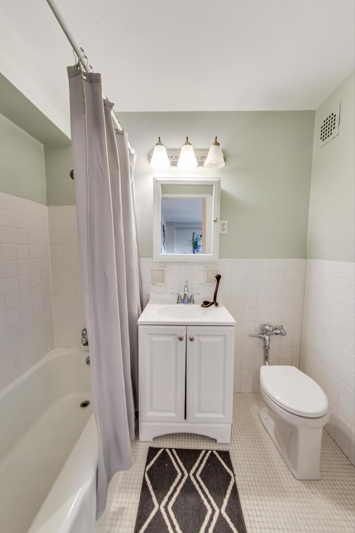 2909 North Sheridan Road, Unit 712 Chicago, IL 60657 - Photo 14 of 16 a bathroom with a sink a toilet and shower