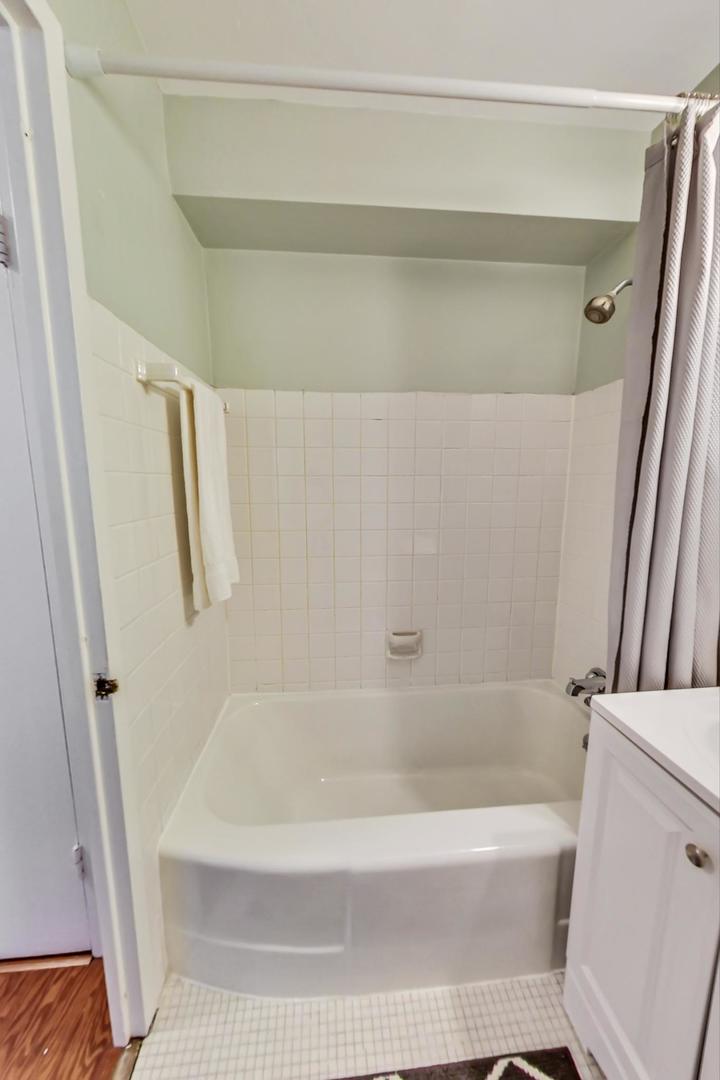 2909 North Sheridan Road, Unit 712 Chicago, IL 60657 - Photo 15 of 16 a bath tub sitting next to a white sink and vanity