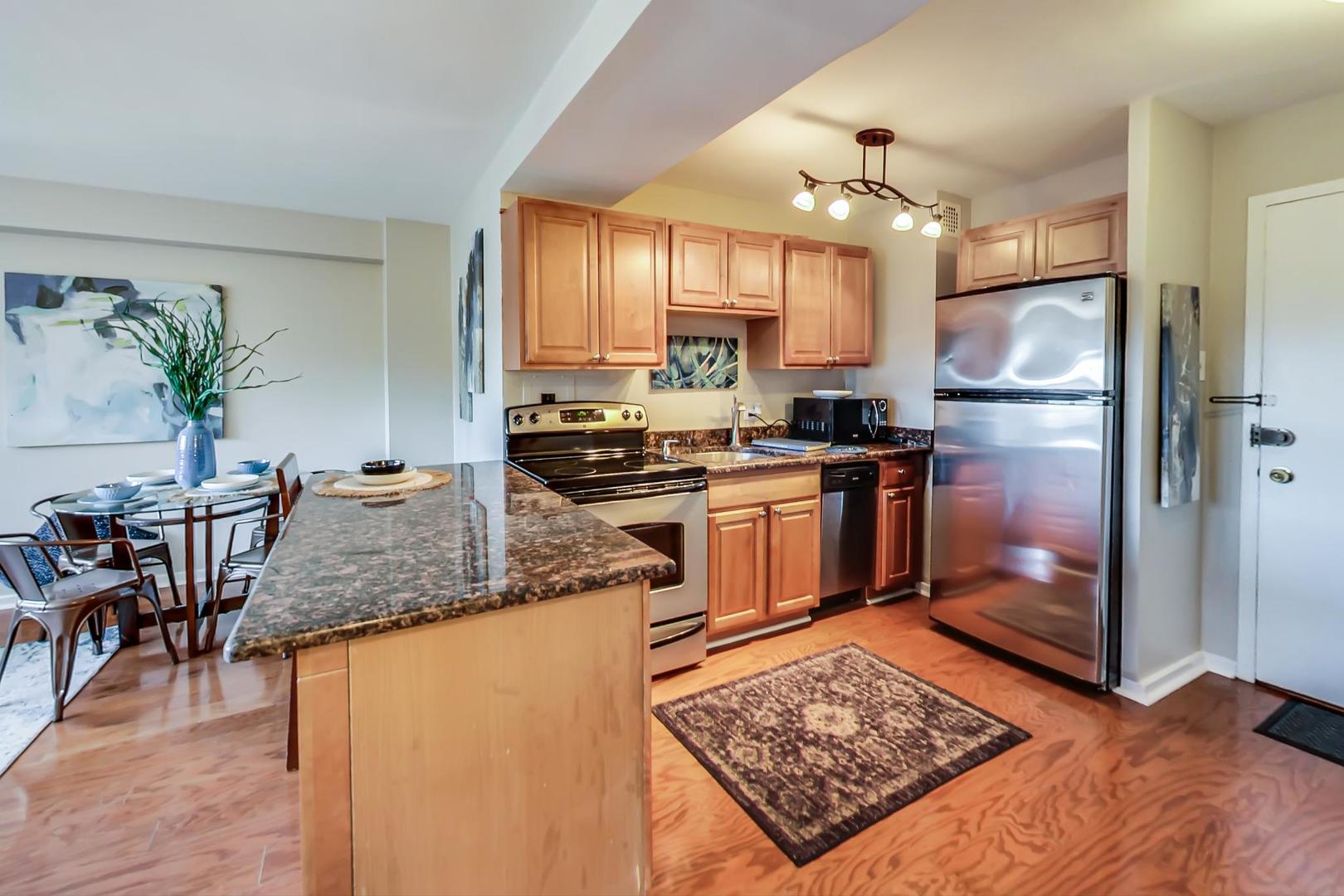 2909 North Sheridan Road, Unit 712 Chicago, IL 60657 - Photo 9 of 16 a kitchen with stainless steel appliances granite countertop a refrigerator stove microwave and sink