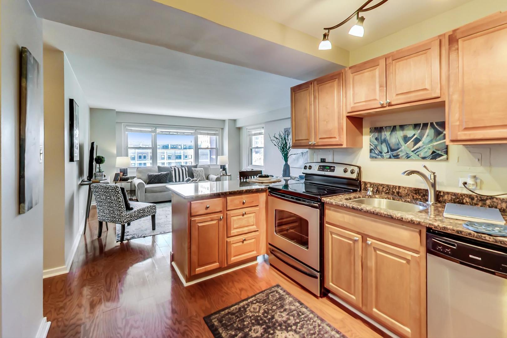 2909 North Sheridan Road, Unit 712 Chicago, IL 60657 - Photo 10 of 16 a kitchen with stainless steel appliances granite countertop a stove top oven a sink dishwasher a dining table and chairs with wooden floor