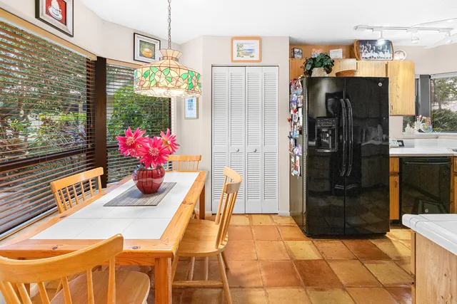 a view of a dining room and livingroom with furniture wooden floor kitchen view