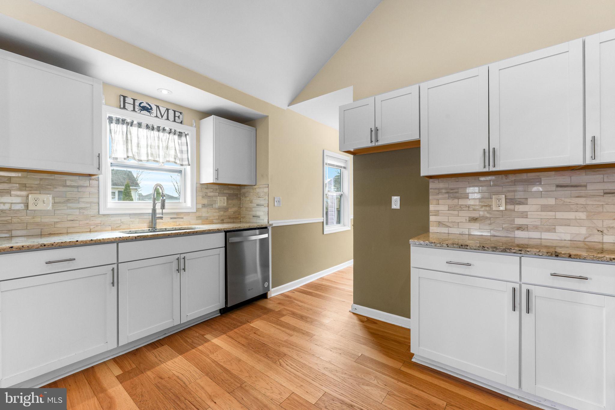 7343 Greenbank Road Baltimore, MD 21220 - Photo 13 of 46 a kitchen with stainless steel appliances granite countertop a refrigerator a sink and white cabinets with wooden floor