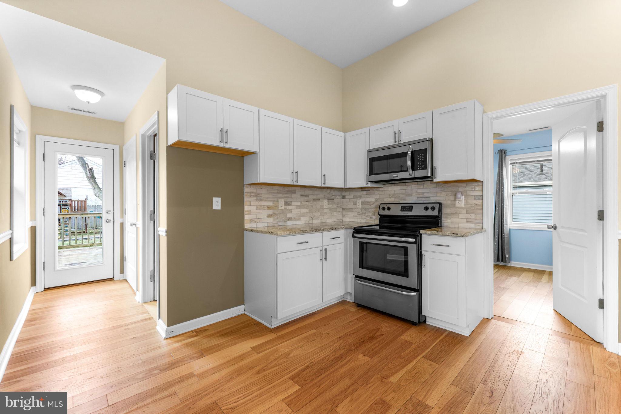7343 Greenbank Road Baltimore, MD 21220 - Photo 14 of 46 a kitchen with granite countertop a refrigerator and a stove top oven