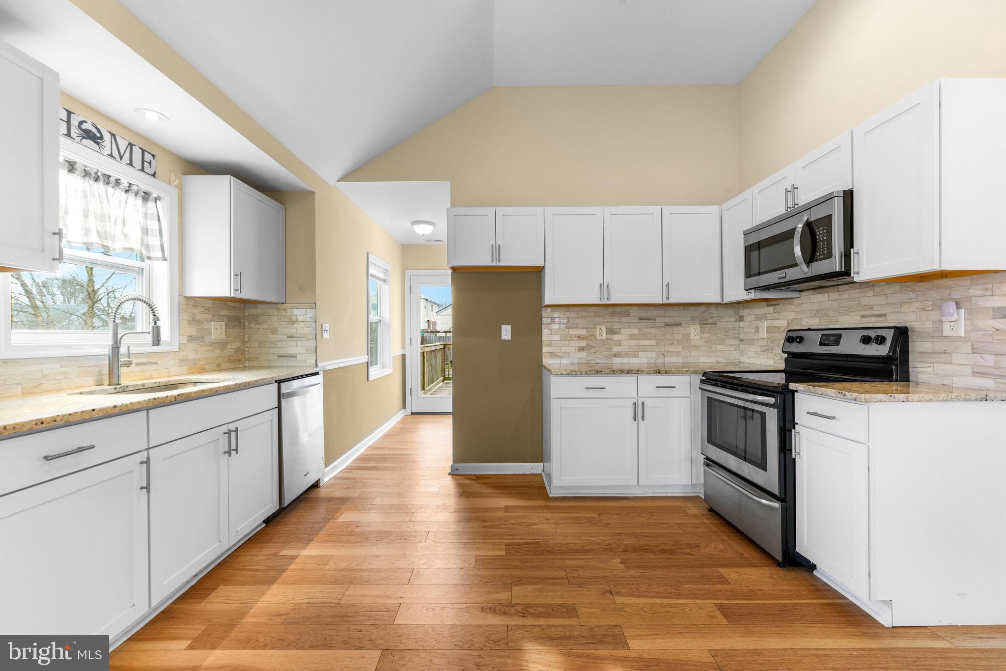 7343 Greenbank Road Baltimore, MD 21220 - Photo 15 of 46 a kitchen with granite countertop a refrigerator and a stove top oven