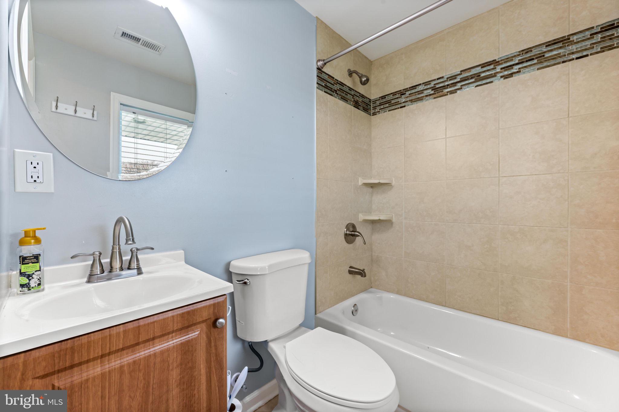 7343 Greenbank Road Baltimore, MD 21220 - Photo 26 of 46 a bathroom with a sink a mirror a toilet and a bathtub