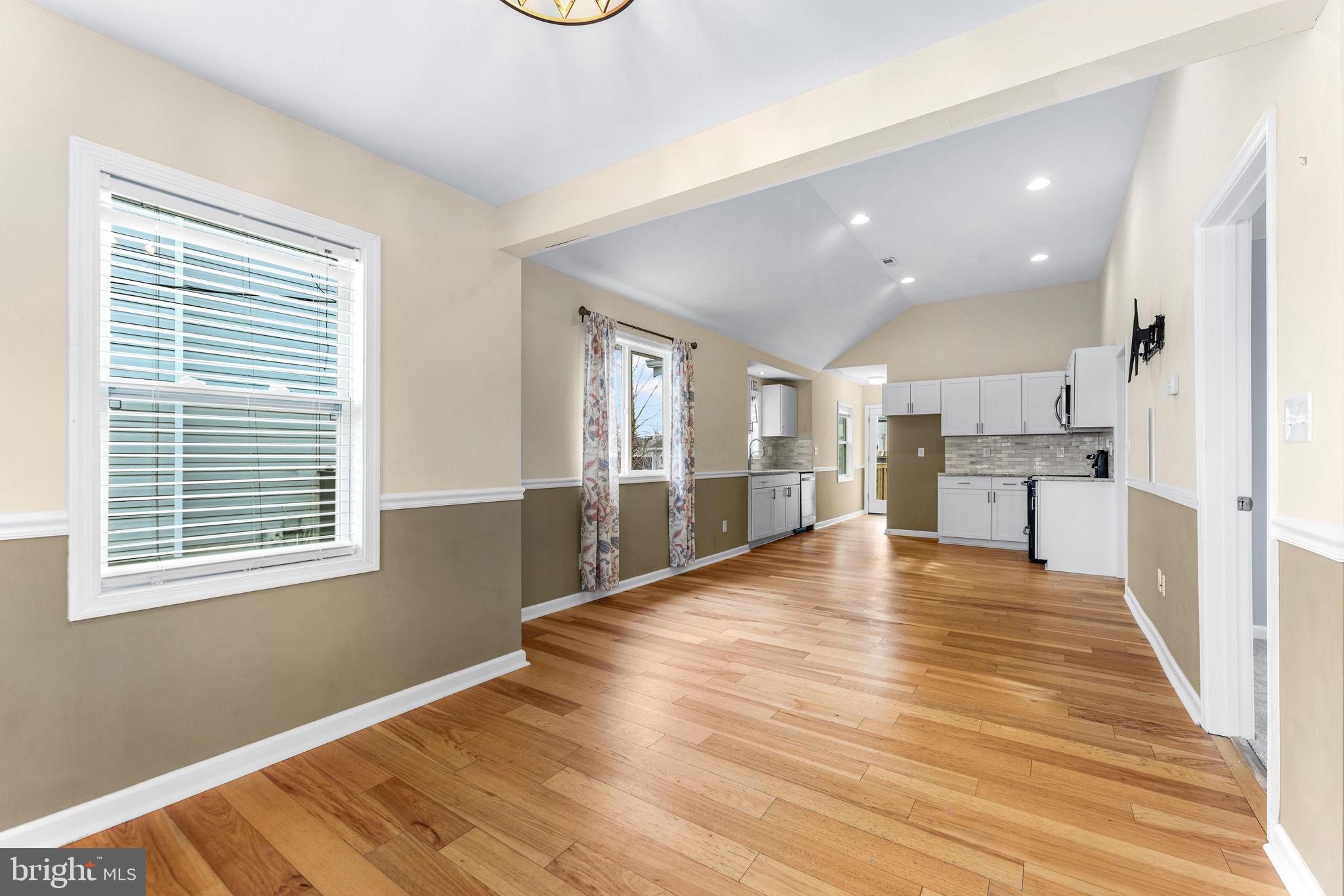 7343 Greenbank Road Baltimore, MD 21220 - Photo 9 of 46 a view of an empty room with wooden floor and a kitchen