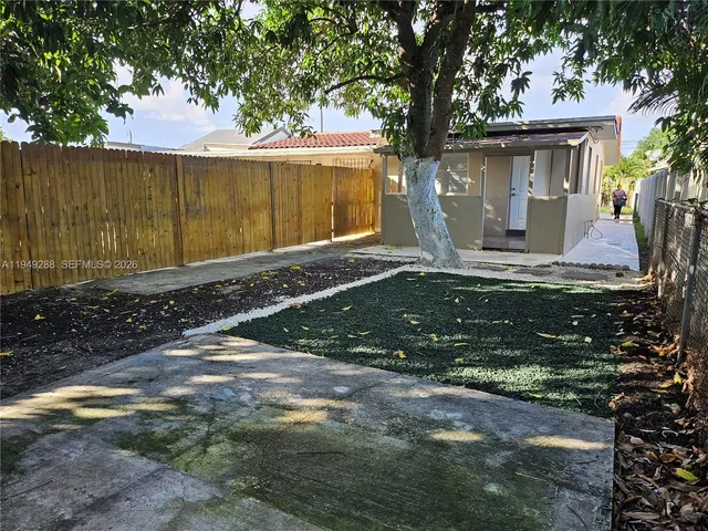 a view of a house with backyard and trees