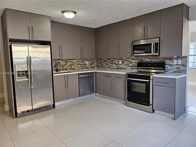 a kitchen with stainless steel appliances granite countertop a stove a refrigerator and a sink