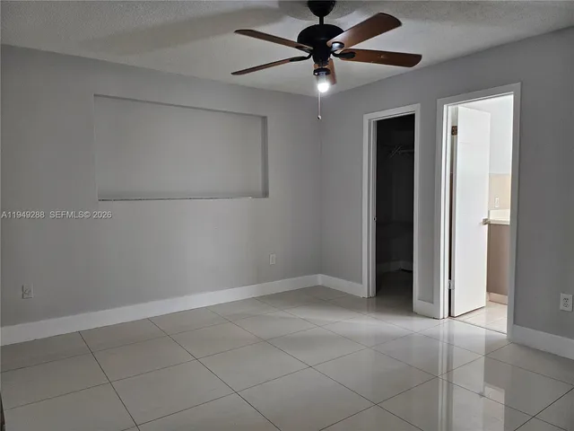 an empty room with closet and a chandelier fan