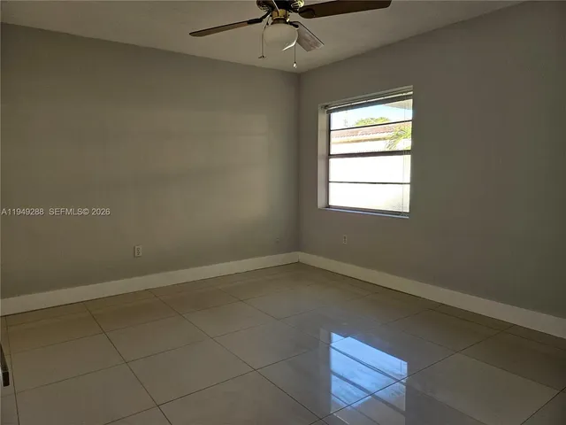 an empty room with a window and a fan