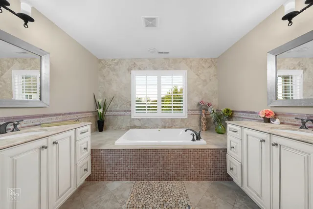 a spacious bathroom with sink a mirror a window and a bathtub