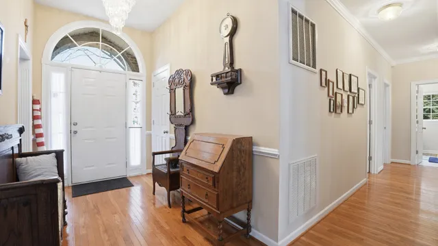 a view of a hallway with wooden floor and staircase