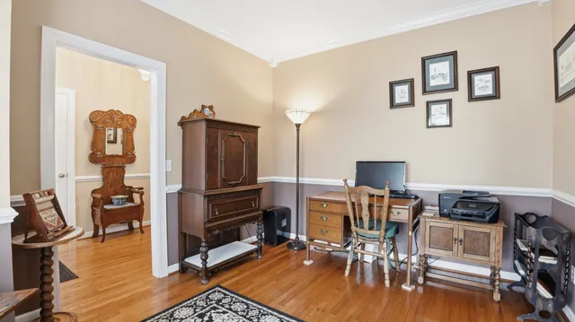 a view of a workspace with furniture and wooden floor