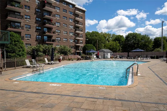 a swimming pool with outdoor seating and barbeque oven