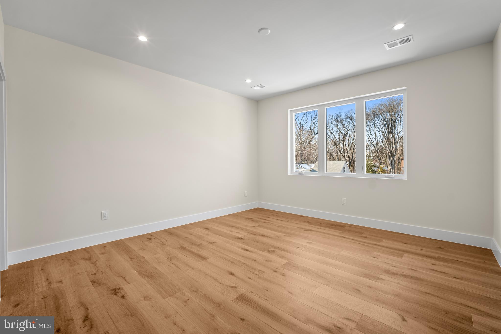 1935 Foxhall Road McLean, VA 22101 - Photo 54 of 80 a view of an empty room with wooden floor and a window