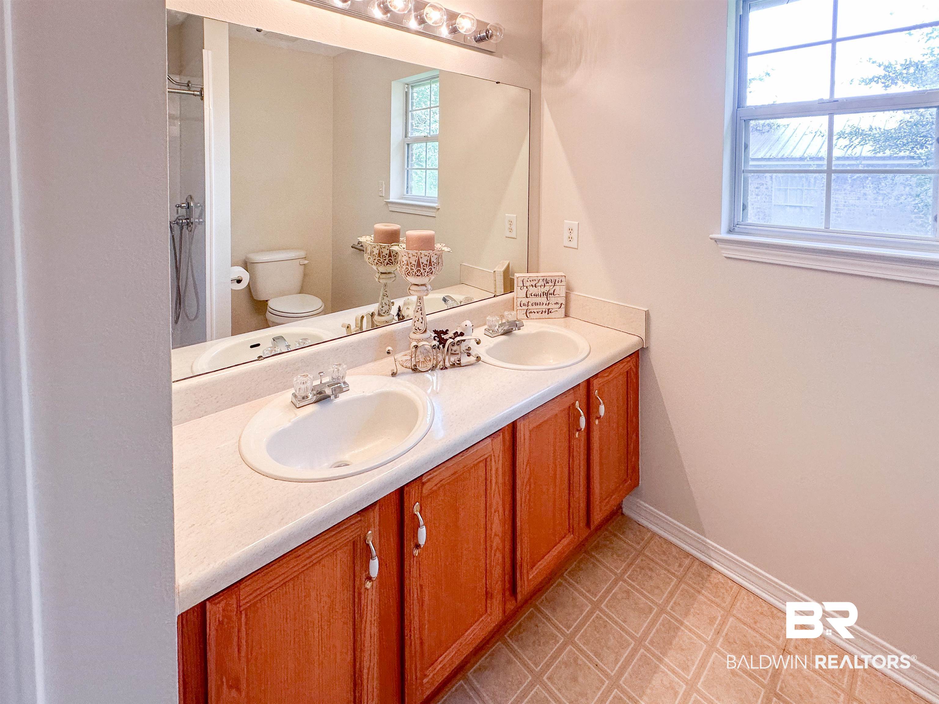 13255 Pointer Drive West Foley, AL 36535 - Photo 15 of 25 Bathroom featuring plenty of natural light, toilet, tile patterned floors, and double sink vanity