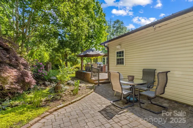 a view of a chair and table in backyard of the house