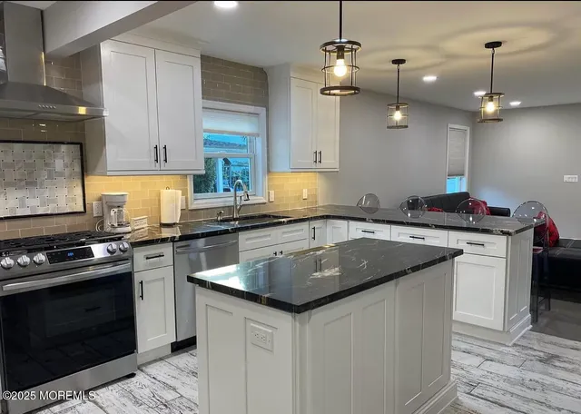 a kitchen with stainless steel appliances granite countertop a sink stove and cabinets