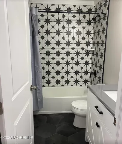 a bathroom with a toilet and a shower curtain