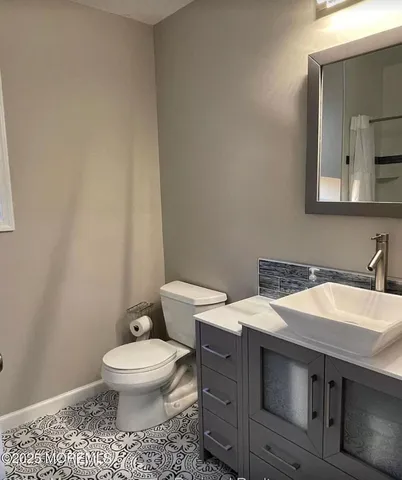 a bathroom with a granite countertop toilet and a sink