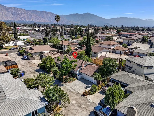 an aerial view of a city with lots of residential buildings and mountain view in back