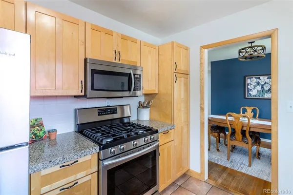 a kitchen with stainless steel appliances granite countertop a stove a microwave and a refrigerator