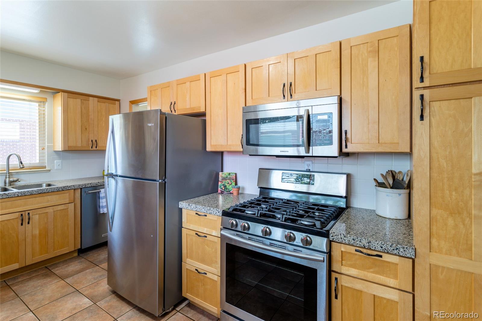 4530 South Inca Street Englewood, CO 80110 - Photo 13 of 37 a kitchen with granite countertop a refrigerator stove and microwave