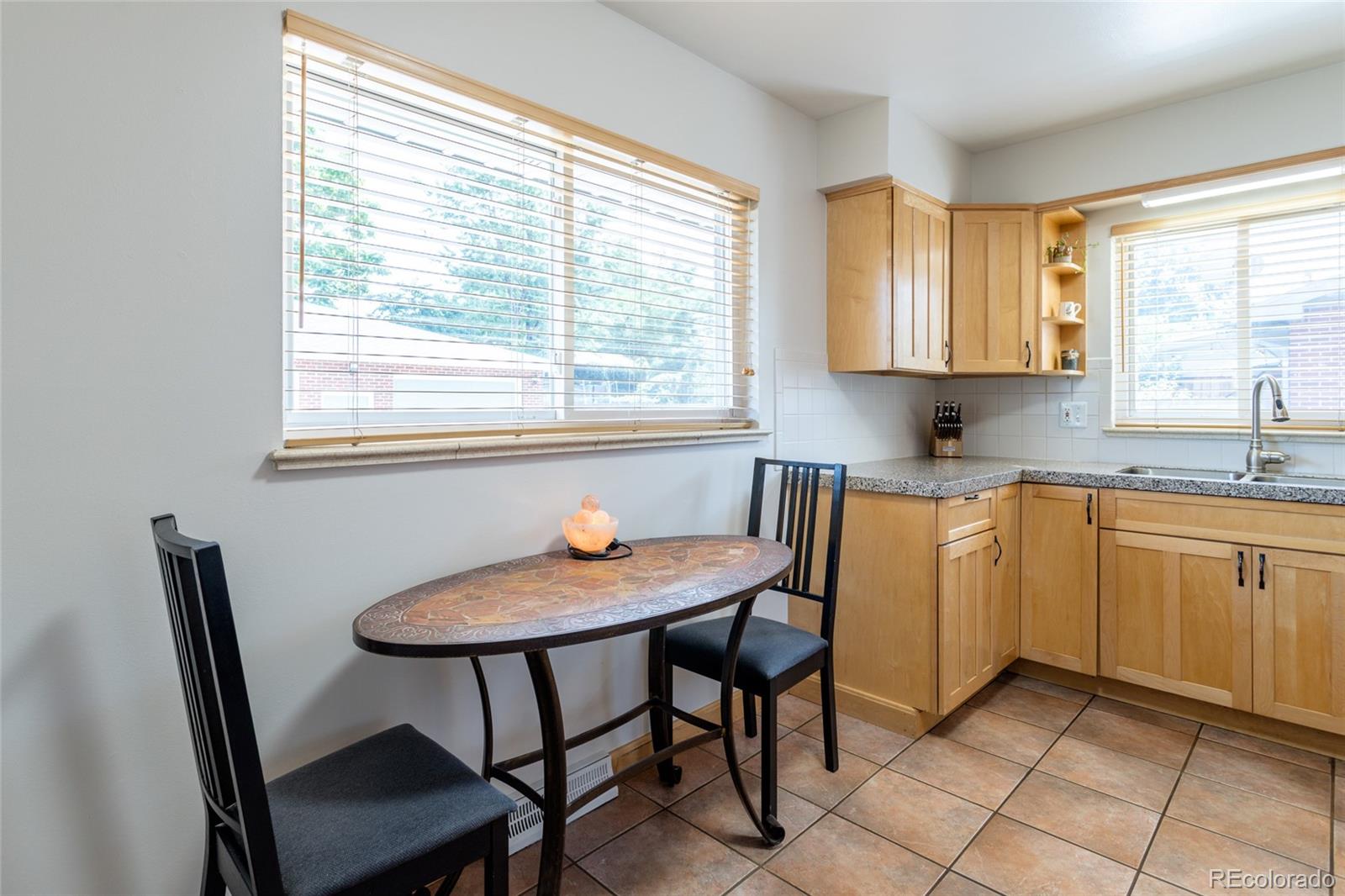 4530 South Inca Street Englewood, CO 80110 - Photo 14 of 37 a kitchen with a table chairs sink and cabinets