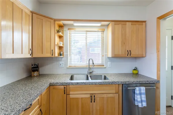 a kitchen with stainless steel appliances granite countertop a sink a refrigerator and a granite counter tops