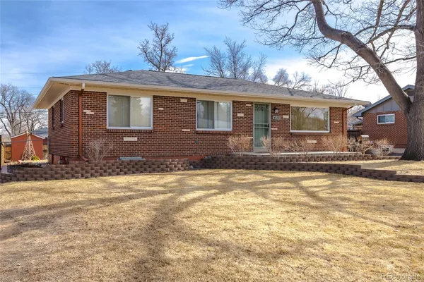 a front view of a house with a yard and large tree